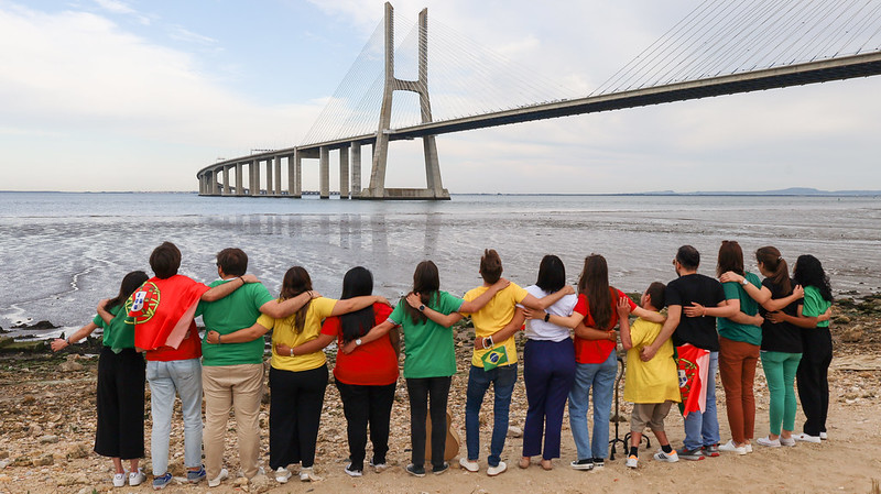 Jóvenes abrazados de espalda bajo el puente Vasco da Gama de Lisboa